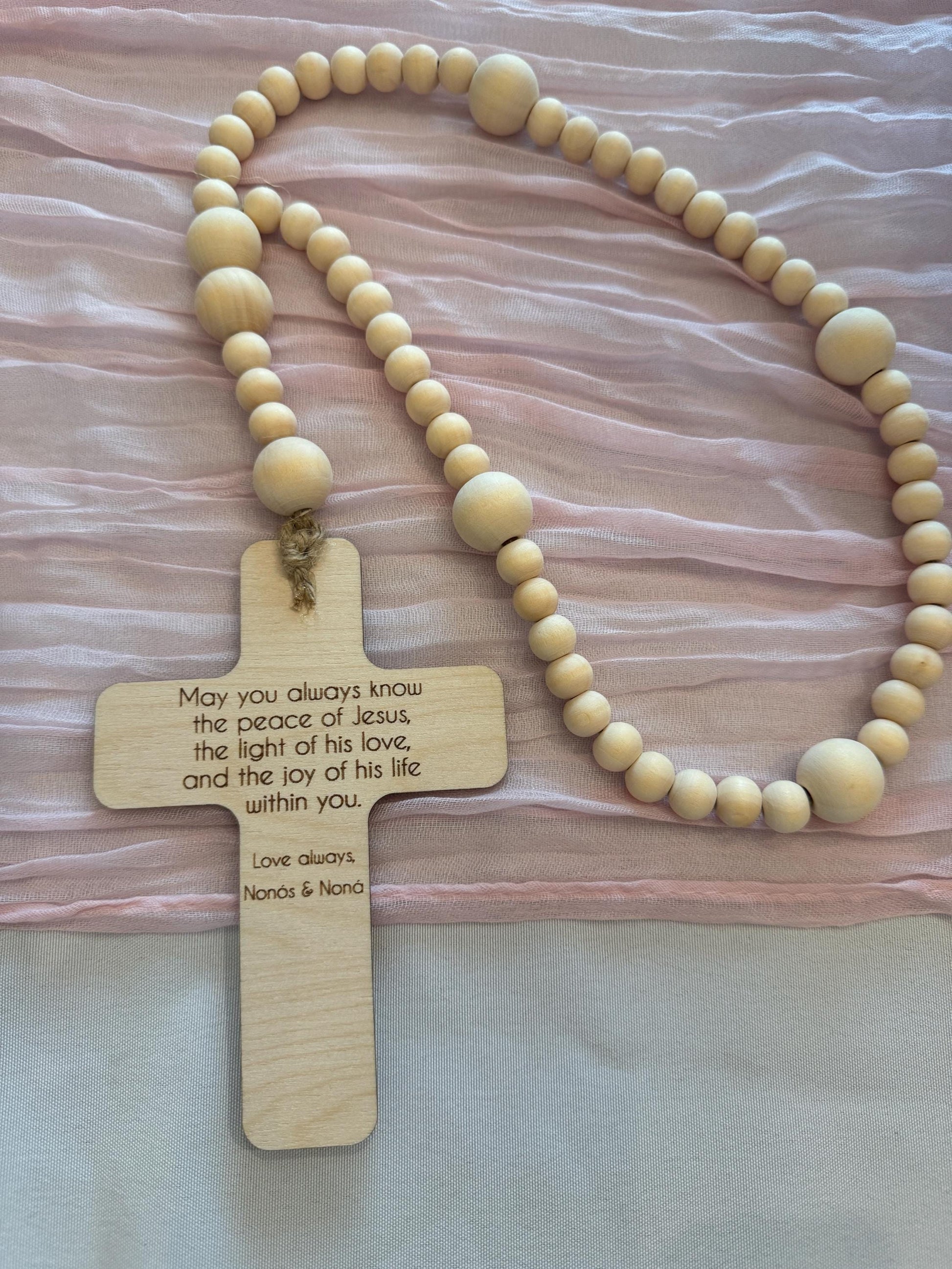 Back engraving on wooden rosary cross featuring a personalized blessing message.
