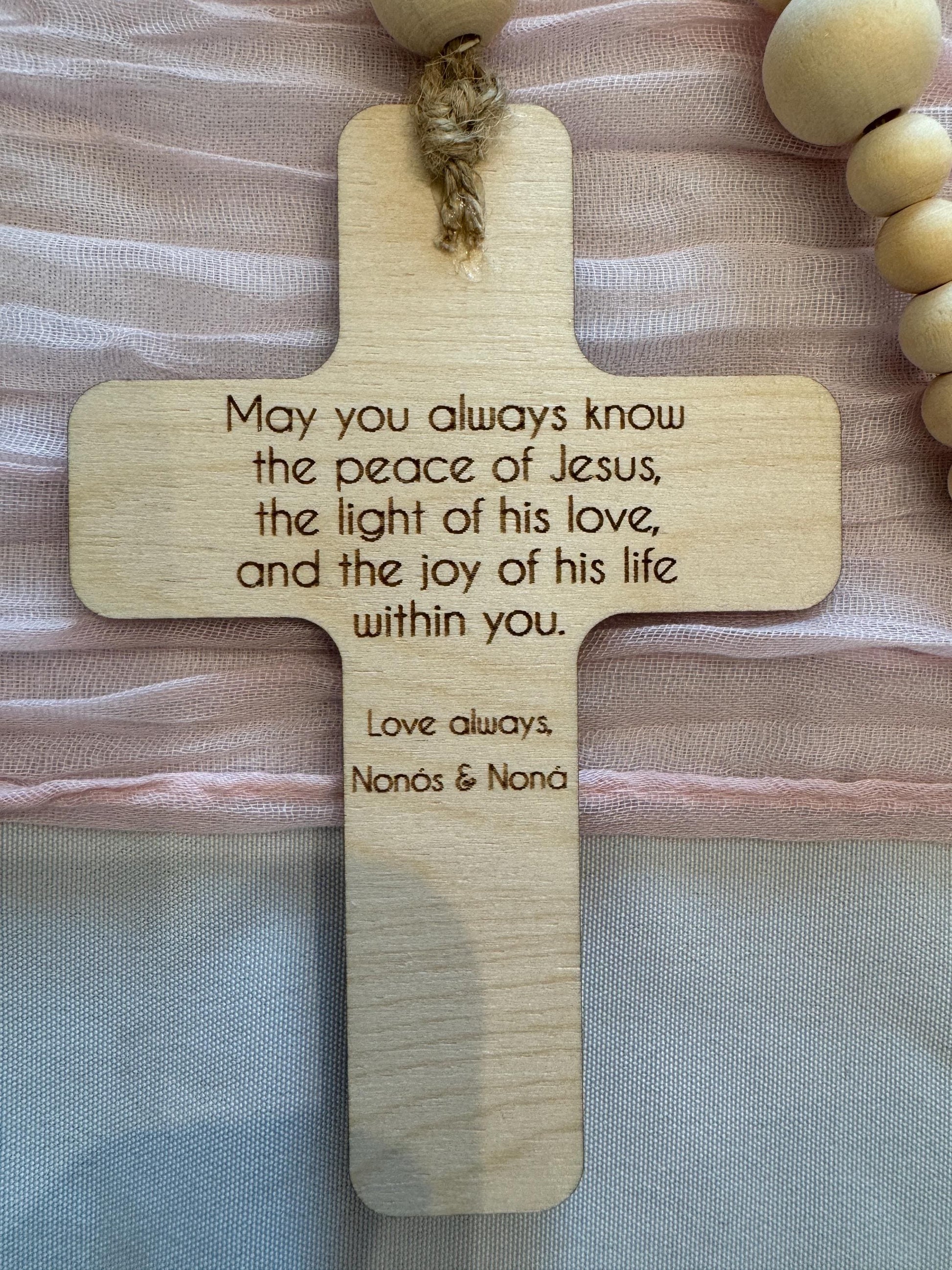 Back engraving on wooden rosary cross featuring a personalized blessing message.
